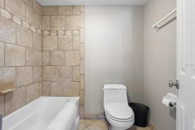 a white toilet sitting next to a bathtub