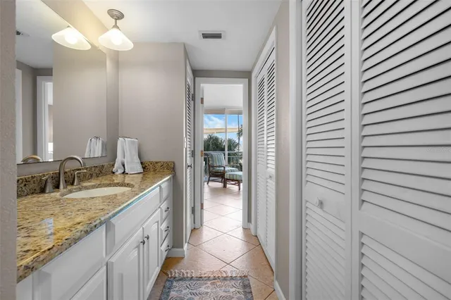 a bathroom with a granite countertop sink and a mirror