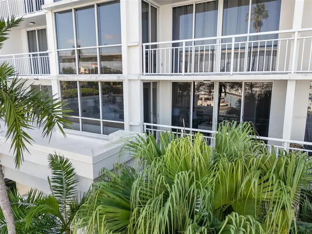 a view of a house with pool plants and wooden fence