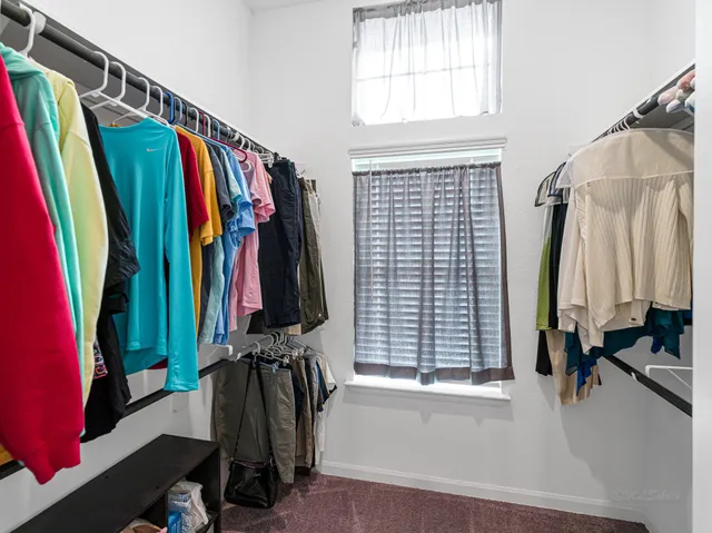 a view of walk in closet with clothes