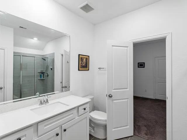 a bathroom with a sink a toilet and shower
