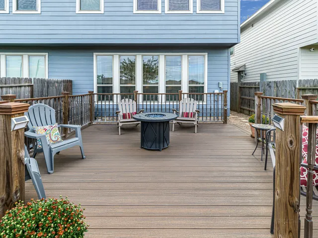 a view of a deck with chairs next to a yard