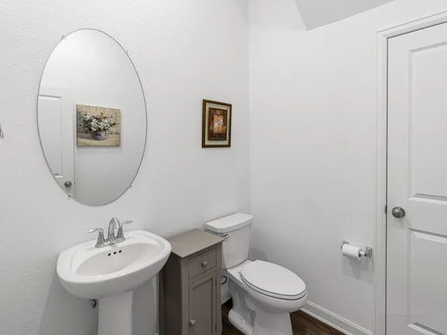 a bathroom with a toilet a sink and mirror