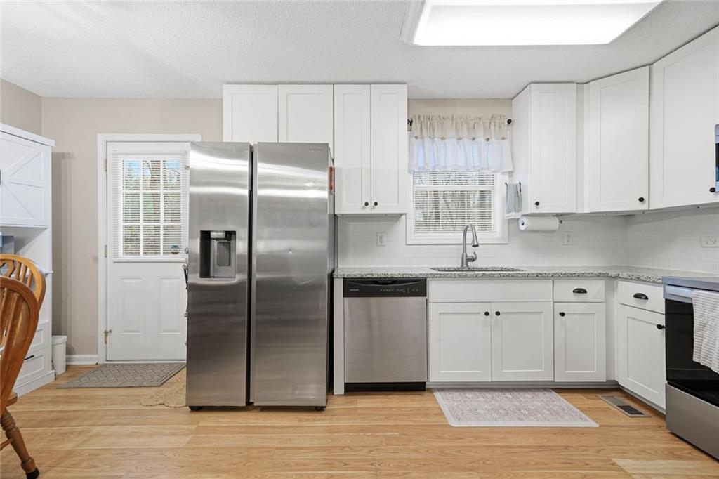 2525 Henderson Mountain Road Jasper, GA 30143 - Photo 8 of 23 a kitchen with stainless steel appliances granite countertop a refrigerator sink and cabinets