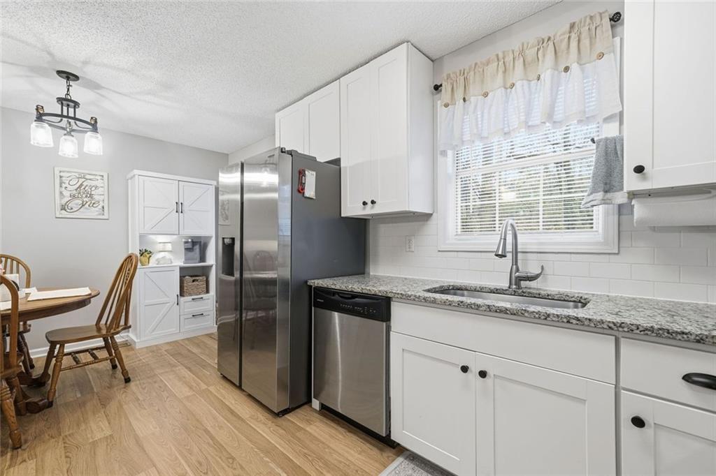 2525 Henderson Mountain Road Jasper, GA 30143 - Photo 10 of 23 a kitchen with granite countertop stainless steel appliances a sink window and cabinets