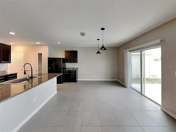 a large kitchen with a large counter top stainless steel appliances and cabinets