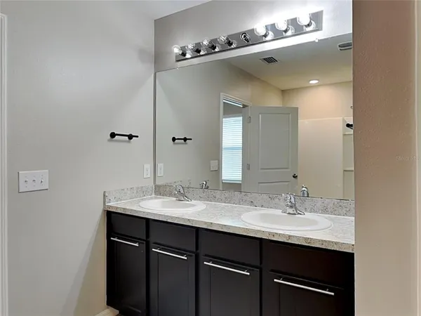 a bathroom with a sink double vanity and a mirror