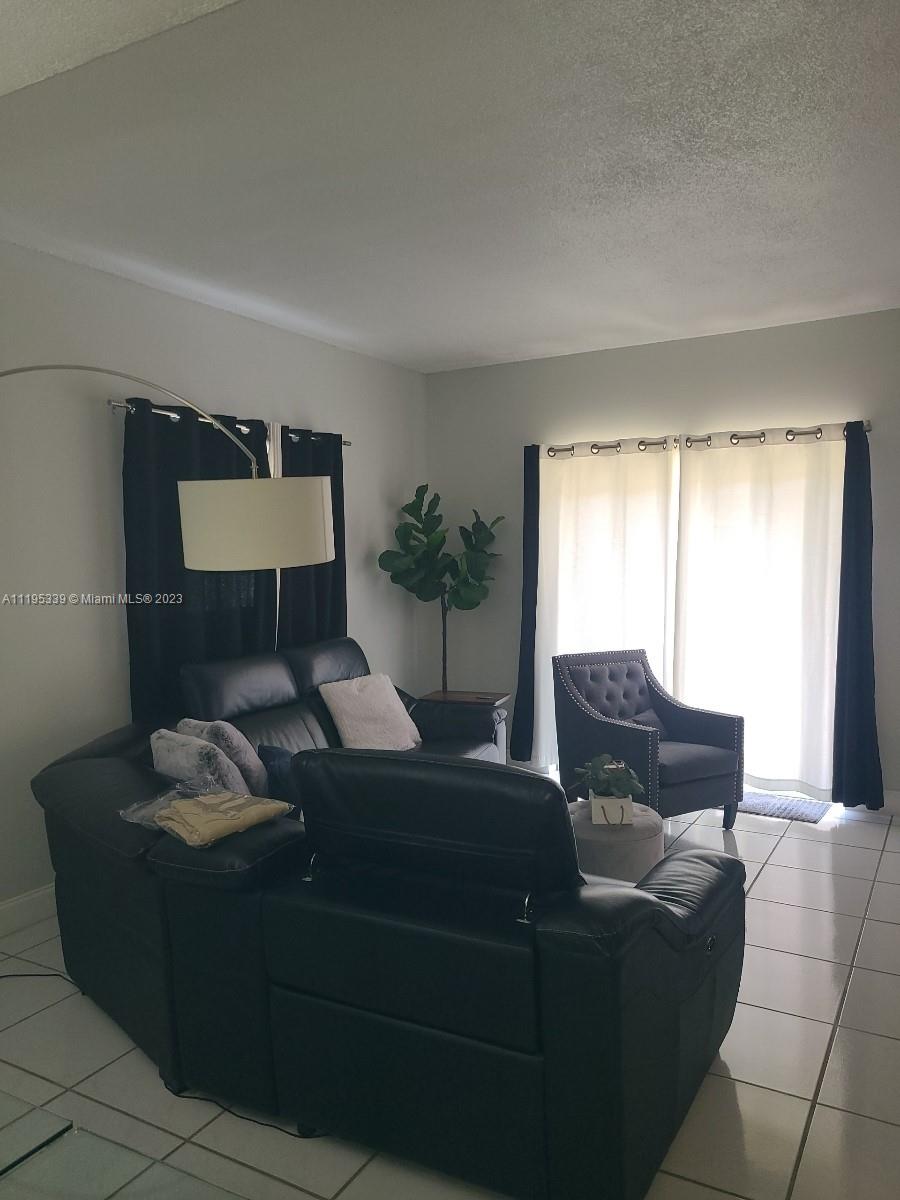 10030 Hammocks Boulevard, Unit 101 Miami, FL 33196 - Photo 12 of 27 a living room with furniture and a window