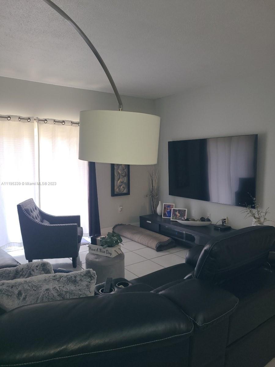 10030 Hammocks Boulevard, Unit 101 Miami, FL 33196 - Photo 13 of 27 a living room with furniture and a flat screen tv
