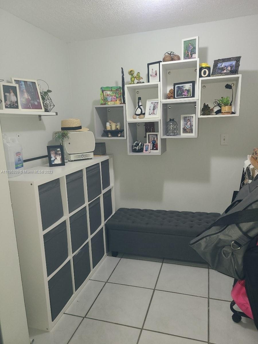 10030 Hammocks Boulevard, Unit 101 Miami, FL 33196 - Photo 18 of 27 a view of a livingroom with shelves