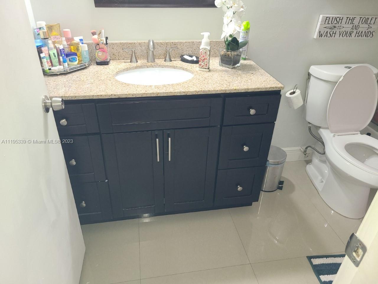 10030 Hammocks Boulevard, Unit 101 Miami, FL 33196 - Photo 23 of 27 a bathroom with a sink a toilet and a mirror