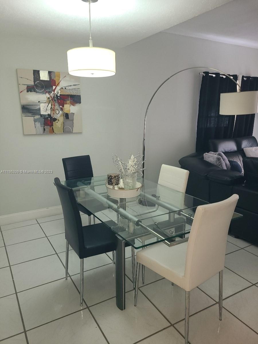 10030 Hammocks Boulevard, Unit 101 Miami, FL 33196 - Photo 26 of 27 a view of a dining room with furniture and chandelier