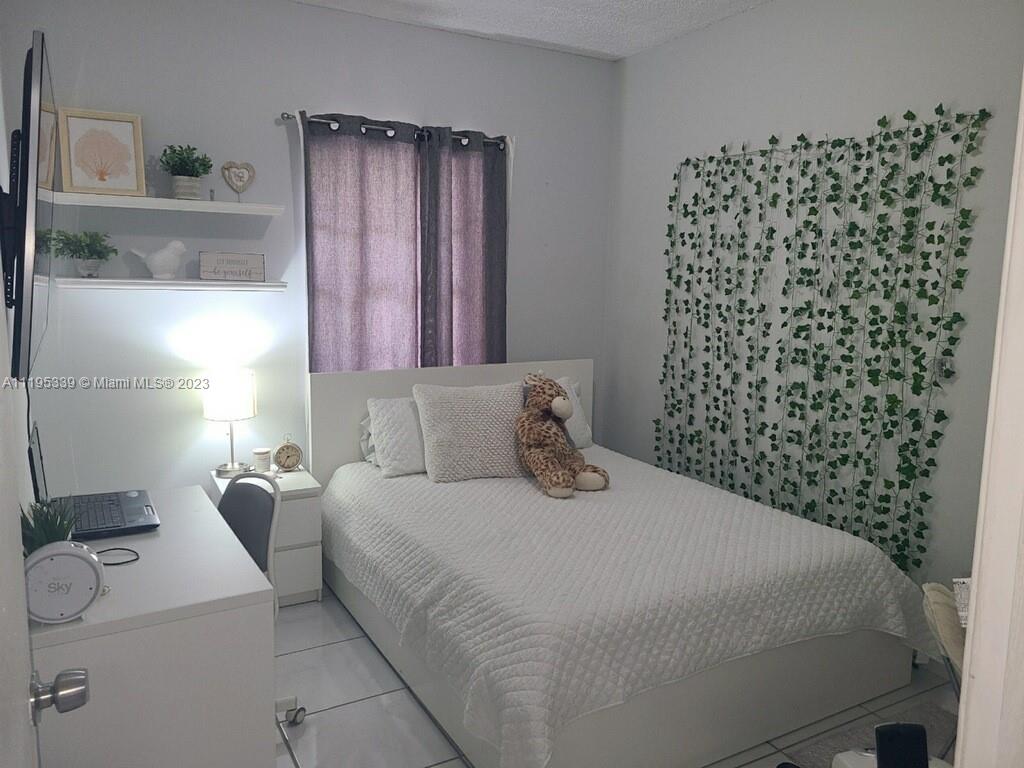 10030 Hammocks Boulevard, Unit 101 Miami, FL 33196 - Photo 5 of 27 a bedroom with a bed and a window