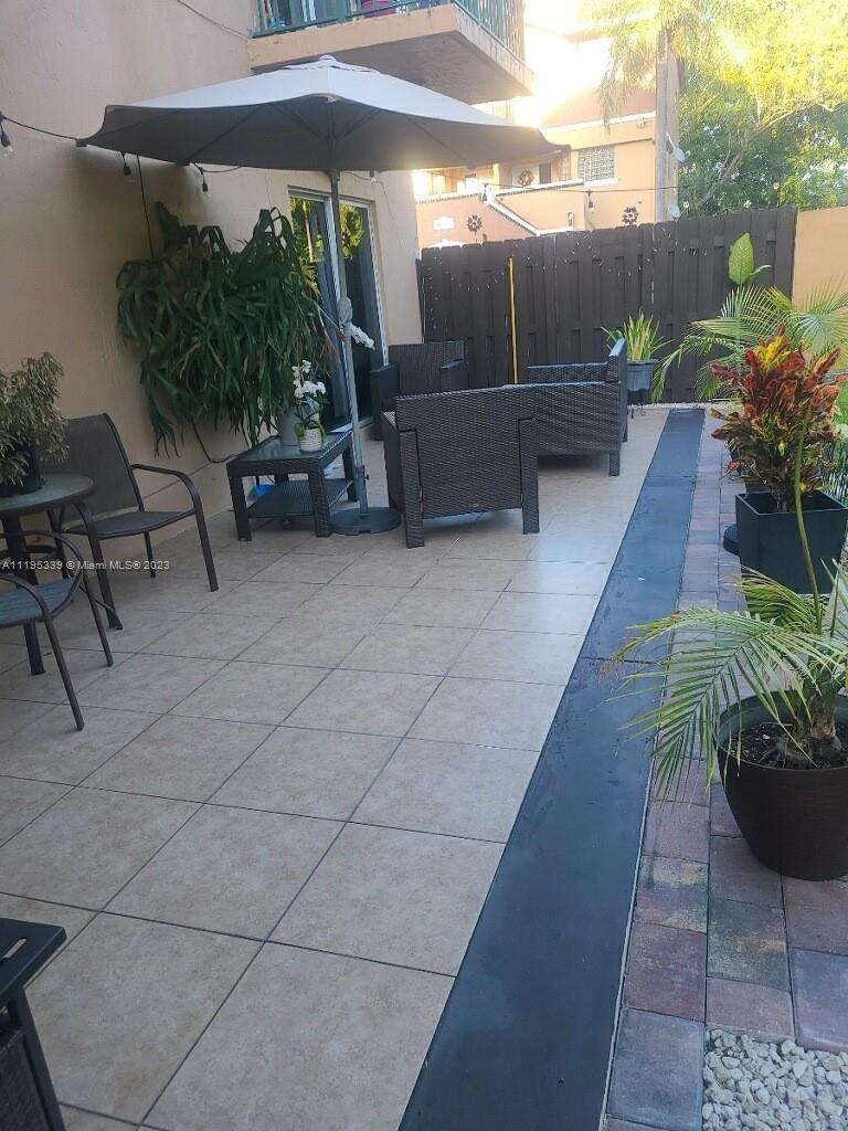 10030 Hammocks Boulevard, Unit 101 Miami, FL 33196 - Photo 9 of 27 a backyard with potted plants and a bench