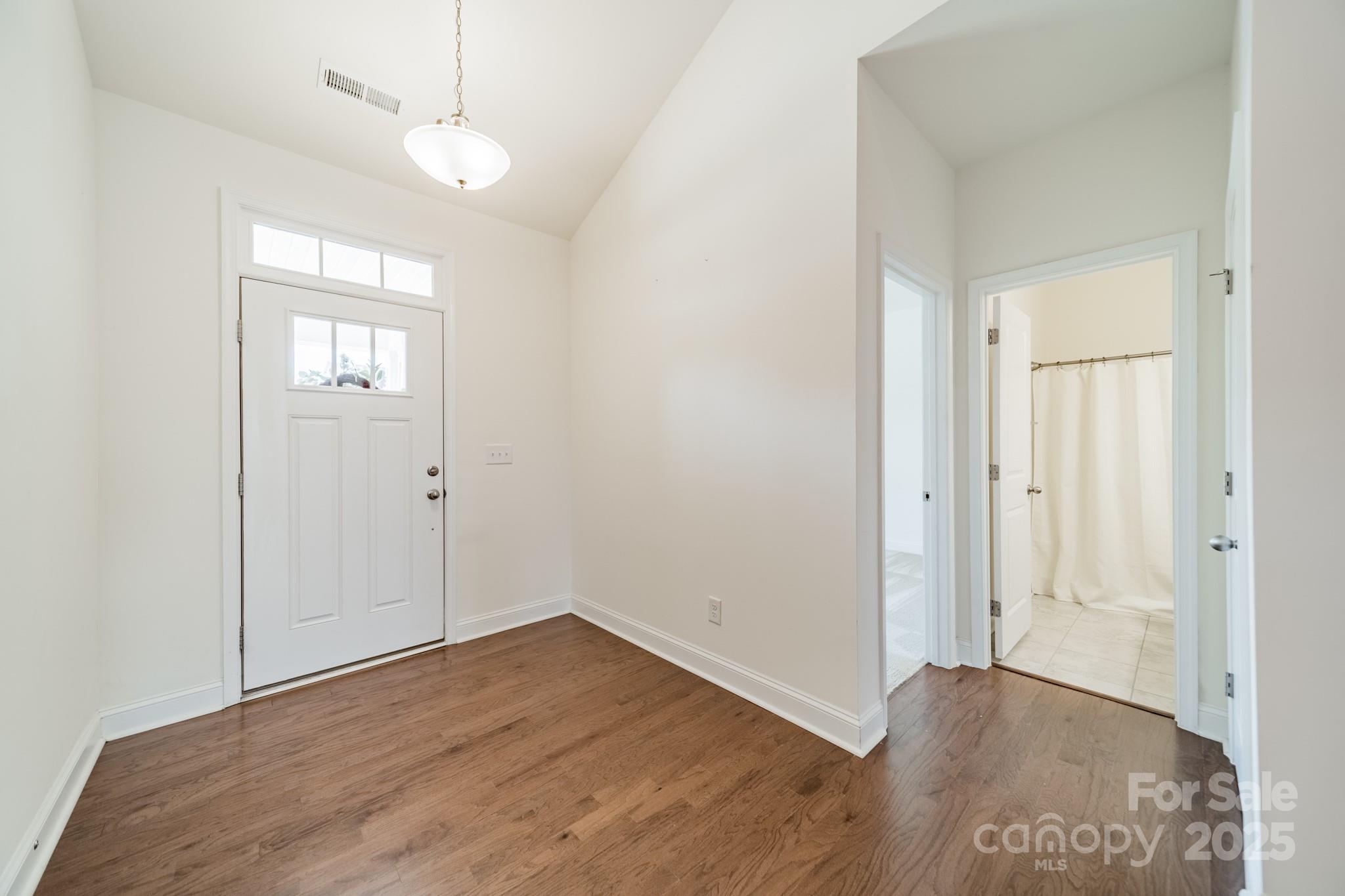 558 Red Wolf Lane Clover, SC 29710 - Photo 2 of 19 an empty room with wooden floor a ceiling fan and windows