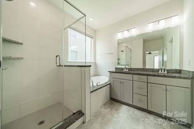 a bathroom with a granite countertop sink a mirror and a shower