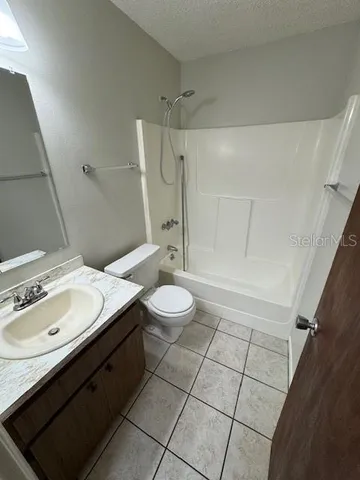 a bathroom with a granite countertop sink toilet a mirror and shower