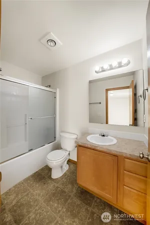 a bathroom with a granite countertop sink toilet a large mirror and shower