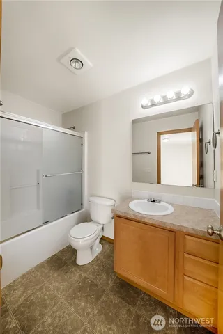 a bathroom with a granite countertop sink toilet a large mirror and shower