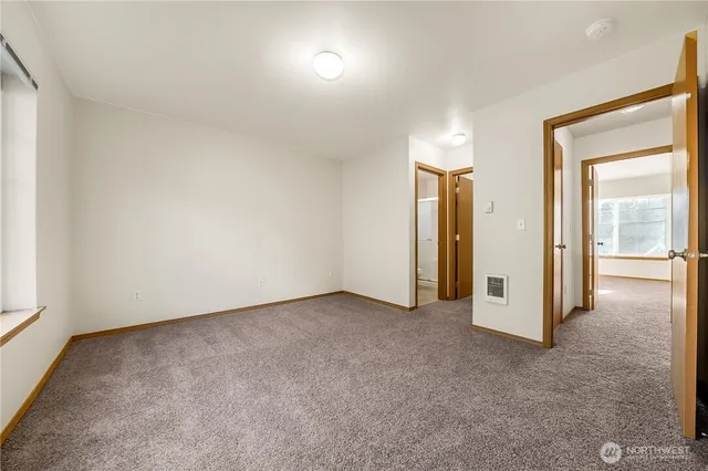 an empty room with closet and a hallway