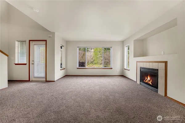 an empty room with windows fire place and fireplace