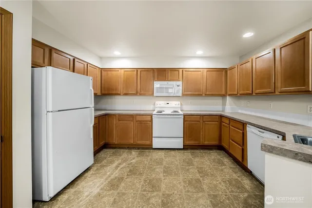 a kitchen with a refrigerator a sink and cabinets
