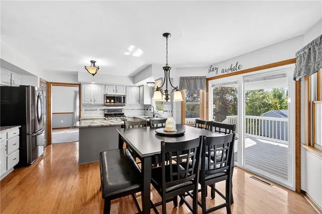 a dining room with furniture a chandelier and wooden floor