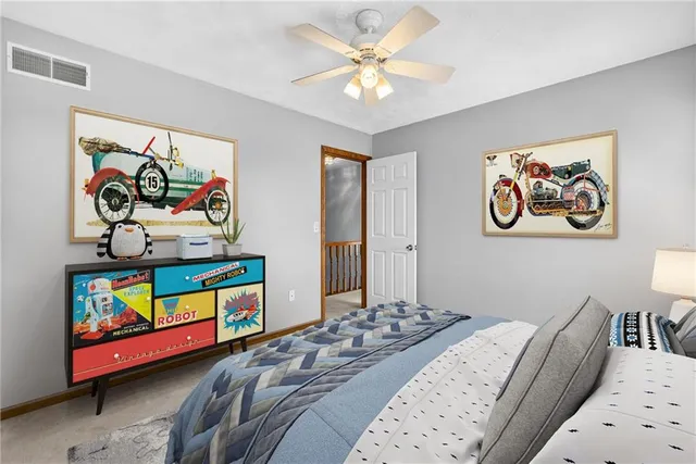 a bedroom with a bed a wall painting on the wall and a window