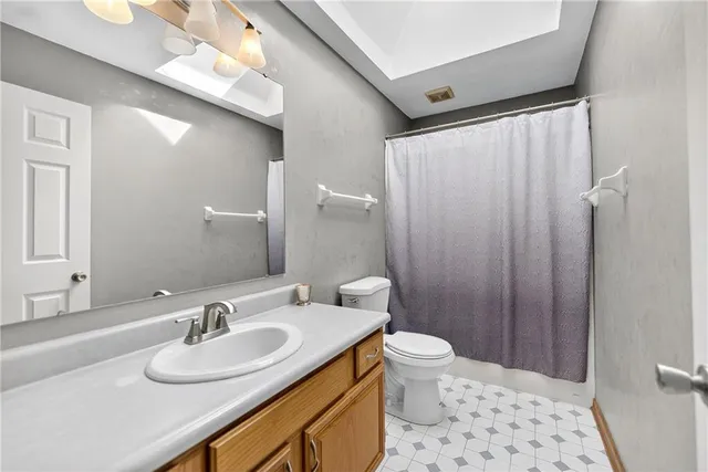 a bathroom with a sink toilet a mirror and shower