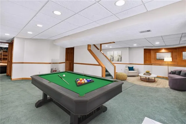 a room with pool table games and windows