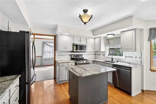 a kitchen with stainless steel appliances granite countertop a stove refrigerator sink and microwave