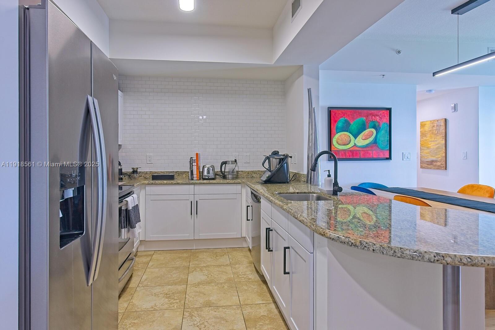 7285 Southwest 90th Street, Unit D613 Miami, FL 33156 - Photo 5 of 20 a kitchen with stainless steel appliances granite countertop a sink and cabinets