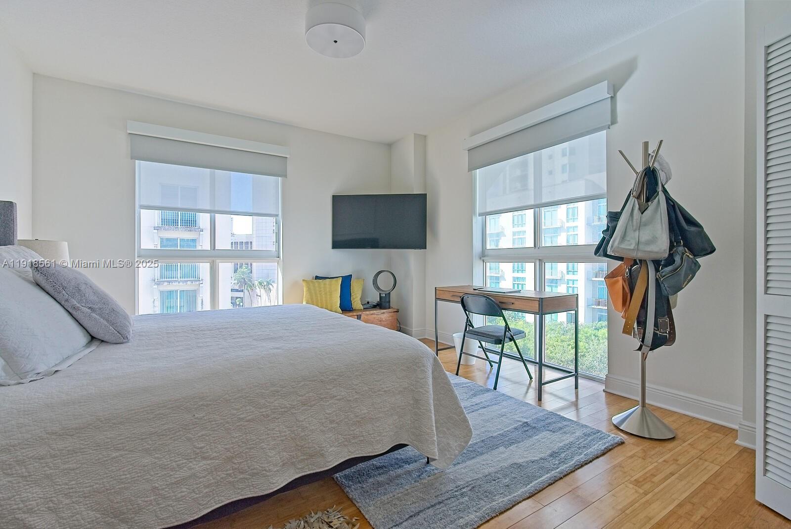 7285 Southwest 90th Street, Unit D613 Miami, FL 33156 - Photo 8 of 20 a bedroom with a bed a flat screen tv and a book shelf