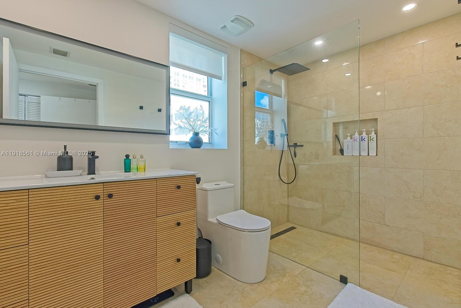 7285 Southwest 90th Street, Unit D613 Miami, FL 33156 - Photo 9 of 20 a bathroom with a granite countertop sink a toilet and shower
