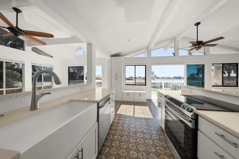 a large kitchen with stainless steel appliances granite countertop a stove and cabinets