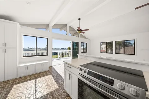 a open kitchen with stainless steel appliances granite countertop a stove and a large window