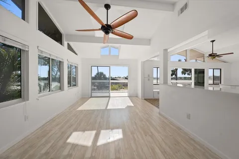 a view of a living room with wooden floor and a ceiling fan
