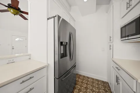 a kitchen with a refrigerator and cabinets
