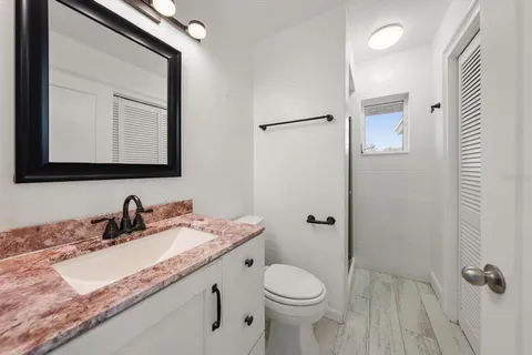 a bathroom with a granite countertop sink toilet and shower