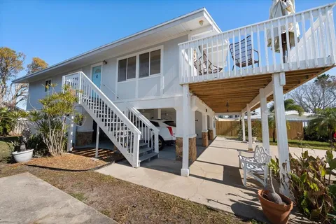 a view of a house with wooden stairs and a small yard