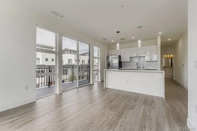 a large white kitchen with a large window and stainless steel appliances