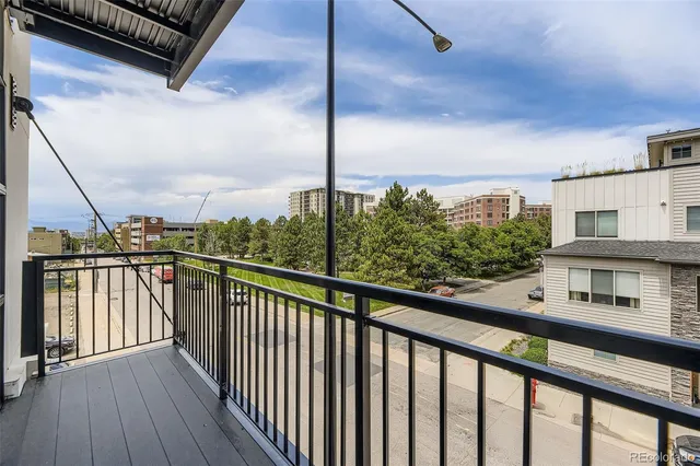 a view of a balcony with wooden floor and iron fence