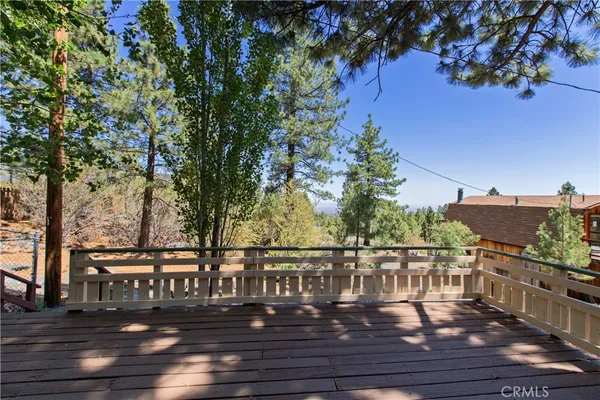 a view of deck with furniture and trees around