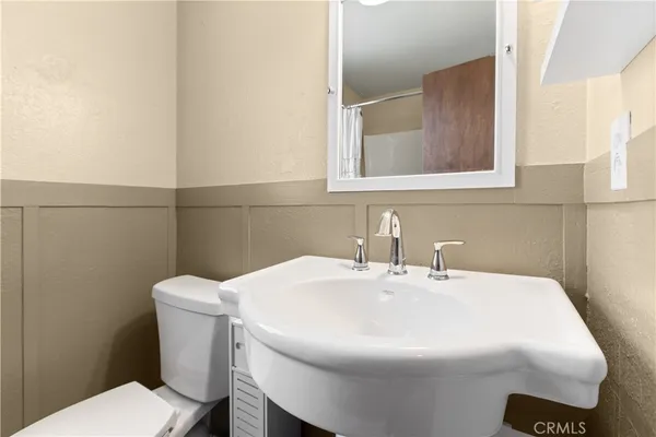 a bathroom with a sink a toilet and mirror