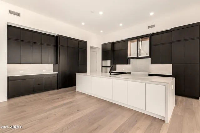 a kitchen with stainless steel appliances kitchen island granite countertop a refrigerator a sink and a stove