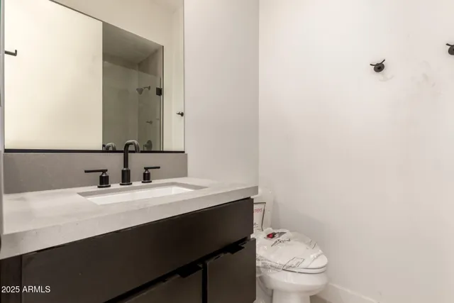 a bathroom with a sink a toilet a mirror and vanity