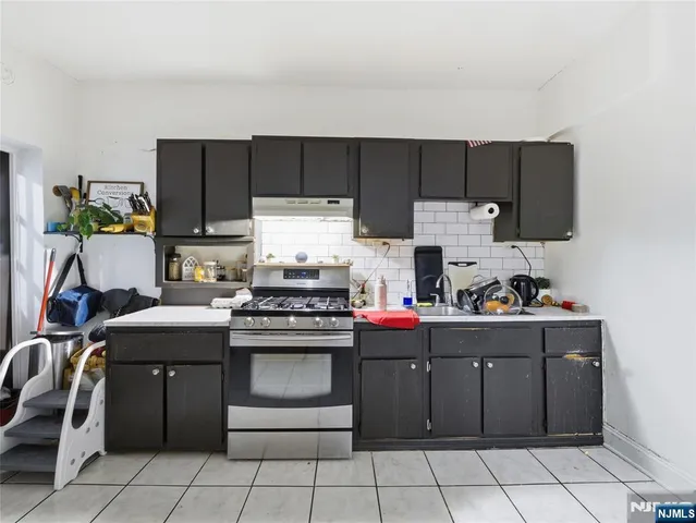 a kitchen with a stove top oven and cabinets
