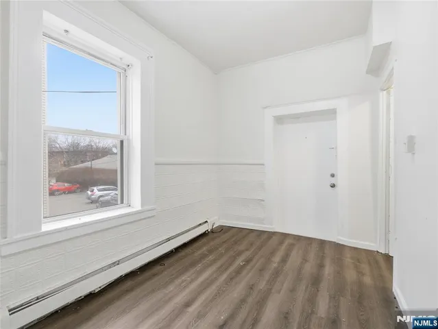 a view of a small space with wooden floor and a window