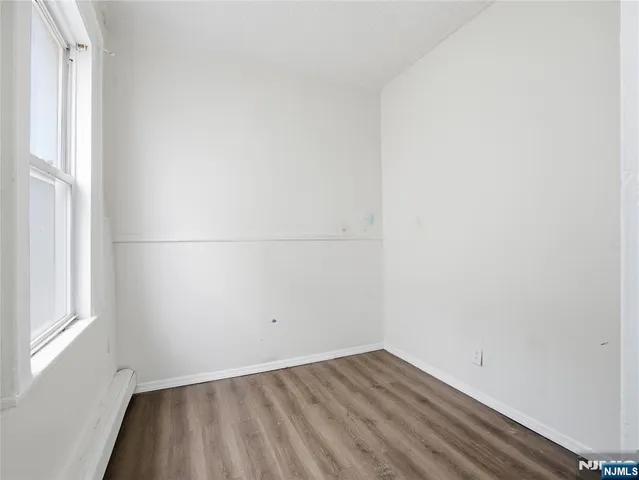 a view of a small space with wooden floor and a window