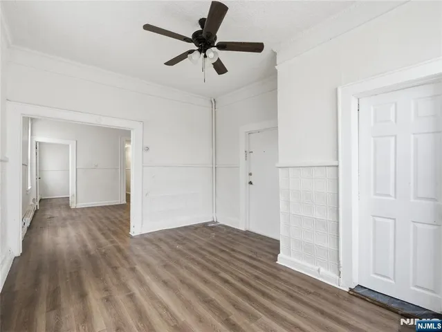 a view of empty room with wooden floor